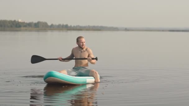 Slowmo Skott Tröjlös Tatuerad Vit Man Sitter Sup Board Sjön — Stockvideo