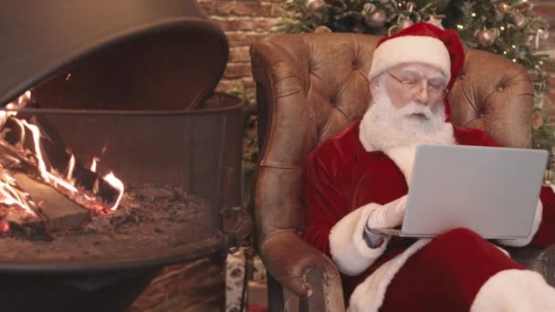 Medium Lang Van Kerstman Zitten Fauteuil Door Open Haard Thuis — Stockvideo