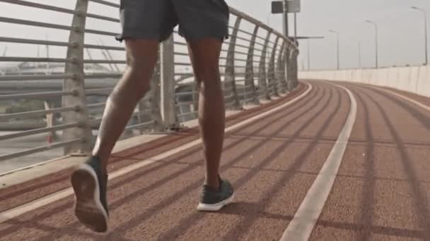 无法辨认的非裔美国运动员在室外跑道上进行短裤慢跑时拍摄的慢镜头 — 图库视频影像