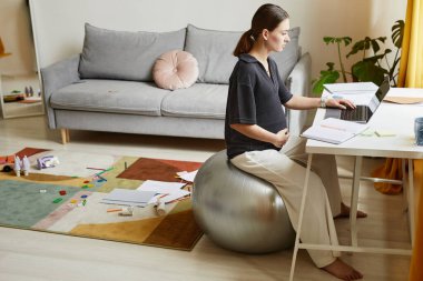 Evde çalışan hamile bir kadın.