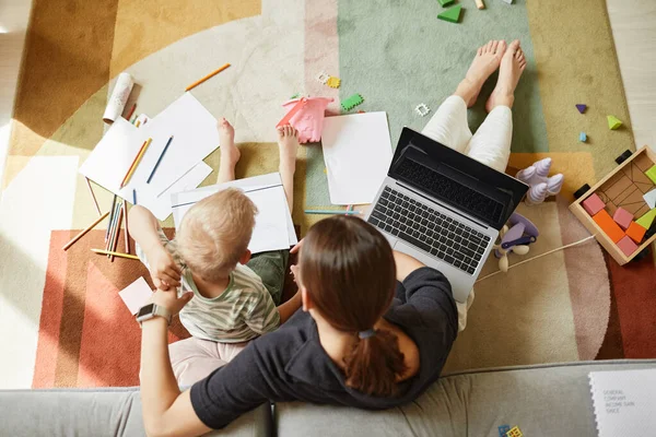 Mãe trabalhando e desenhando com filho ao mesmo tempo — Fotografia de Stock