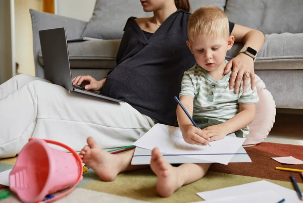 Figlio disegno mentre madre lavoro — Foto Stock