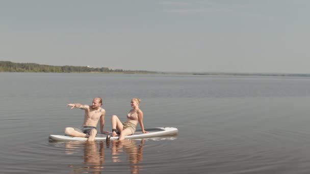 Långsam Bred Bild Unga Kaukasiska Par Vilar Sup Styrelser Sjön — Stockvideo