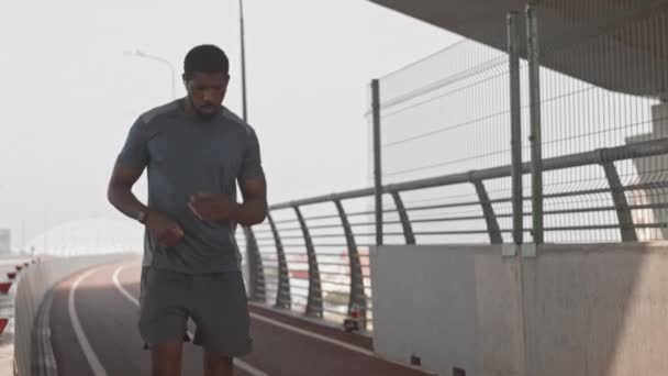 Lento Disparo Hombre Afroamericano Forma Corriendo Por Puente Ciudad Haciendo — Vídeo de stock