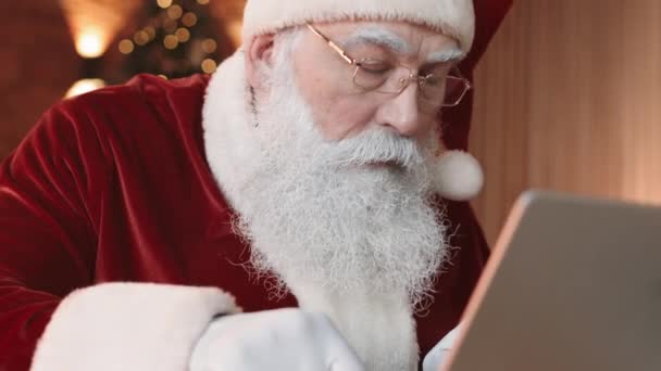 Naklápění Seriózního Santa Clause Červenobílém Kostýmu Kloboukem Sezení Stolem Používání — Stock video