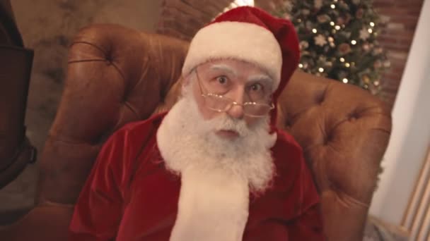 Tracking Van Kerstman Rood Wit Kostuum Zitten Een Fauteuil Thuis — Stockvideo