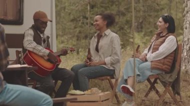 Afrika kökenli Amerikalı genç bir adam gitar çalıp bira içerken, yazlarını ormanda geçirirken, neşeli çoklu etnik arkadaşların birlikte küçük bir evde şarkı söylemesinin yavaş çekimi.
