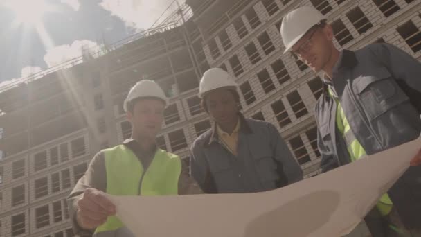 Baixo Ângulo Inclinado Três Engenheiros Diversos Vestindo Uniforme Com Chapéus — Vídeo de Stock