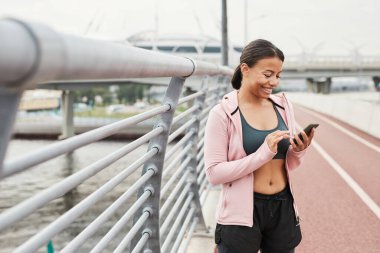 Antrenman sırasında cep telefonu kullanan kadın