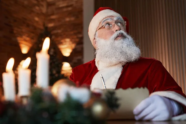 Pensive Santa psaní dopis — Stock fotografie