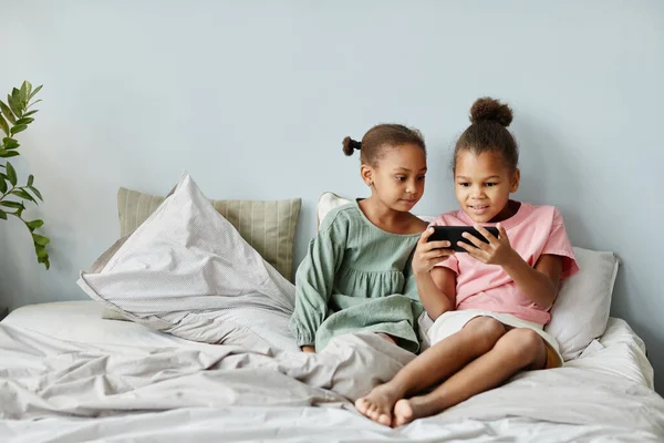Дві дівчини використовують смартфон вдома — стокове фото