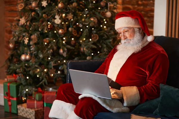 Santa Claus werken met laptop — Stockfoto