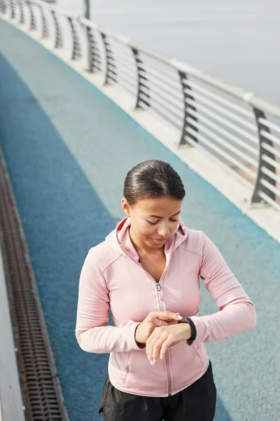 Mujer usando pulsera de fitness durante la carrera — Foto de Stock
