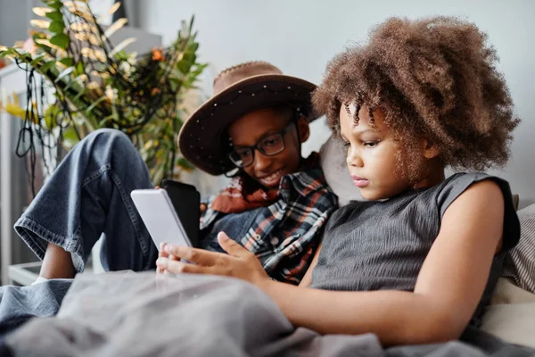 Enfants afro-américains utilisant un smartphone sur le lit — Photo