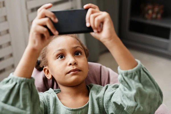 Афроамериканська дівчинка вдома користується смартфоном — стокове фото