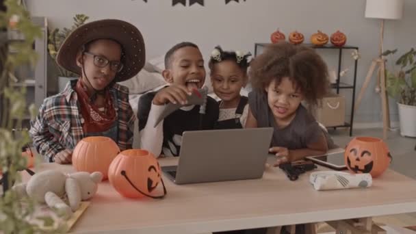 Powolne Ujęcie Czworga Afroamerykanów Kostiumach Halloween Siedzących Razem Przy Biurku — Wideo stockowe