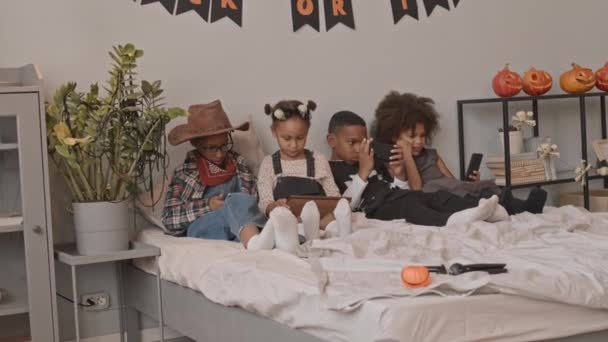 Slowmo Tiro Alunos Afro Americanos Trajes Halloween Sentado Cama Jogando — Vídeo de Stock