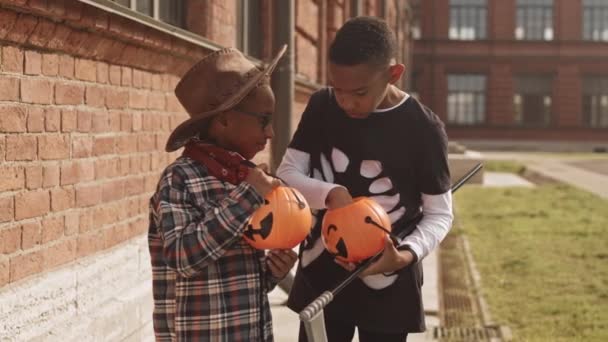 Średnie Powolne Ujęcie Uroczych Afroamerykanów Kostiumach Halloween Jedzących Słodycze Dyniowych — Wideo stockowe