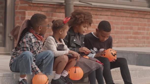 Lento Disparo Cuatro Niños Afroamericanos Disfraces Halloween Sentados Escaleras Aire — Vídeos de Stock