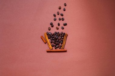 Tarçınlı kahve fincanı modeli ve bej arkaplanda kahve çekirdekleri. Tasarım için yaratıcı alan. Moda minimalisti. Yakın plan.