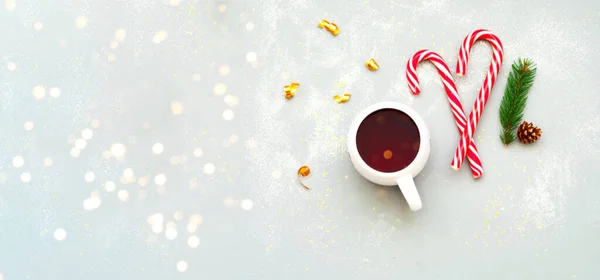Белая чашка с чаем и рождественская свеча на сером фоне с искрами. Креативное пространство копирования. — стоковое фото