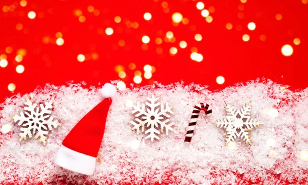 Εορταστικό κόκκινο φόντο με λάμψη. Χριστουγεννιάτικα ξύλινα ειδώλια σε χιονισμένη υφή. Σπιτικά Χριστούγεννα.Δημιουργικός χώρος αντιγραφής. — Φωτογραφία Αρχείου