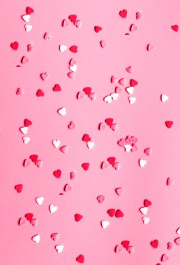 Pembe arka planda çok renkli kalp şeklinde tatlı bir dekor. Sevgililer Günü. Tebrik kartı ya da metin tasarımının şablonu.