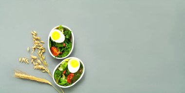 Avokado ve marul salatası salatası gri arka planda fırlatma kutusunda. Dokunulmaz yemek siparişi. Sağlıklı yaşam tarzı kavramı. Tasarım için yaratıcı alan, modaya uygun renk 2021. Yakın plan.