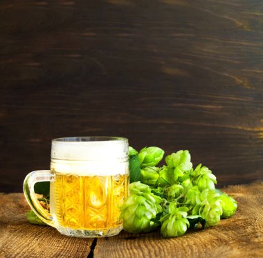 Ahşap arka planda hafif biralı taze zıpzıp ve cam bardak. Uluslararası Bira Günü veya Ekim Festivali bira festivali. Yakın plan.