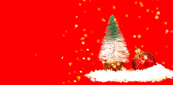Karácsonyfa játék fenyő és piros karácsonyi csecsebecse hó textúra. Karácsonyi üdvözlőlap helyet a szöveges. — Stock Fotó