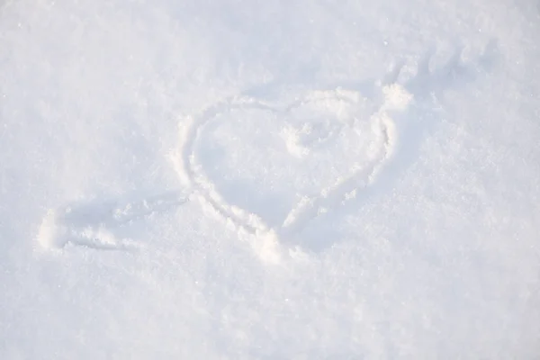 One heart in the snow. A heart is drawn on the snow close-up. The shape of heart on the snow. Winter background.