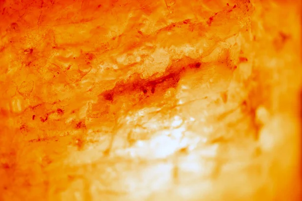 Salt lamp. The texture of the salt lamp, rock orange, close up. Blurred background