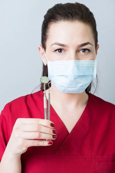 Retrato de una mujer dentista sosteniendo herramientas — Foto de Stock