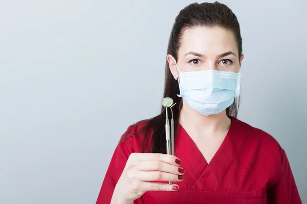 Mujer dentista sosteniendo herramientas dentales en el espacio de copia — Foto de Stock