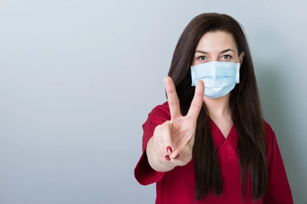 Dentist woman showing peace gesture on gray copy space — Stock Photo, Image