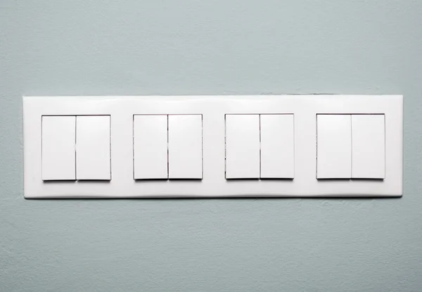 Close-up of multiple light switches on blue background — Stock Photo, Image