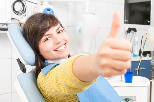 Mulher sorridente paciente mostrando como no consultório odontológico — Fotografia de Stock