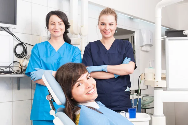 Портрет усміхненої жінки-стоматолога і помічника з жіночим візерунком — стокове фото
