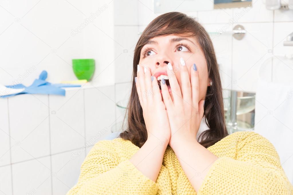Close-up of woman with open mouth being scared of dentist
