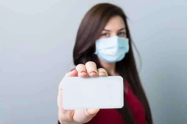 Mujer doctora sosteniendo una tarjeta blanca en blanco — Foto de Stock