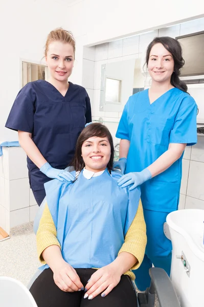 Dentista feliz com assistente e paciente em consultório odontológico — Fotografia de Stock