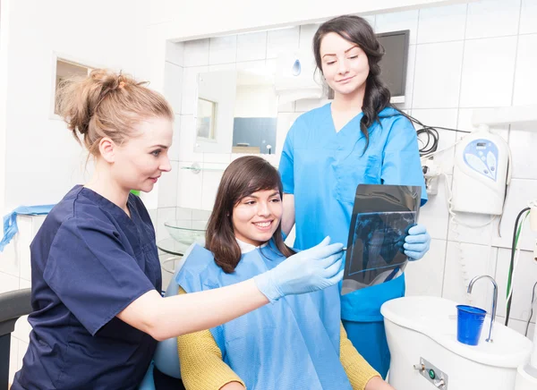 Mujer sonriente dentista explicando los detalles de la radiografía — Foto de Stock