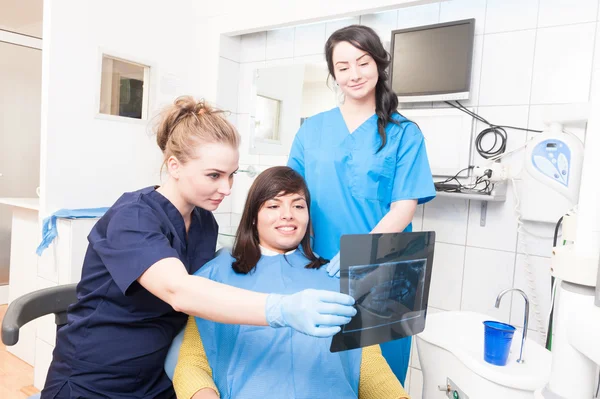 Woman doctor is showing the x-ray of teeth to patient — 图库照片