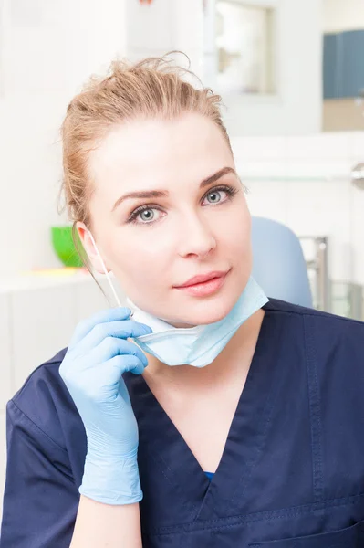 Mulher dentista em seu escritório vestindo uniforme e máscara — Fotografia de Stock