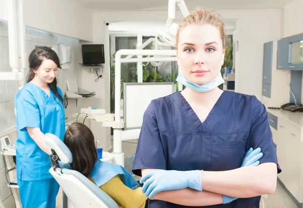 Muito feminino médico segurando braços cruzados no consultório odontológico — Fotografia de Stock