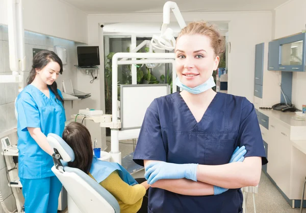 Bello medico sorridente che esamina la macchina fotografica in clinica dentale — Foto Stock