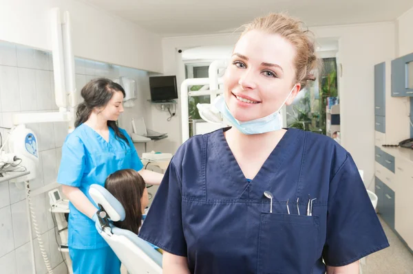 Dentista feminina sorridente com ferramentas dentárias no bolso — Fotografia de Stock