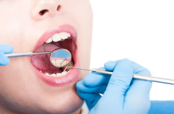 Dentista está olhando para a boca de uma mulher com espelho dental — Fotografia de Stock