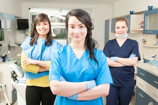 Young smiling assistant in front of her coworker and patient — Stock Photo, Image