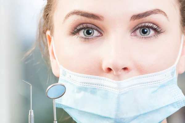 Close up attractive dentist face with tools and mask — Stock Photo, Image